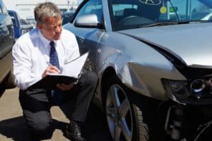 adjuster inspects car involved in accident