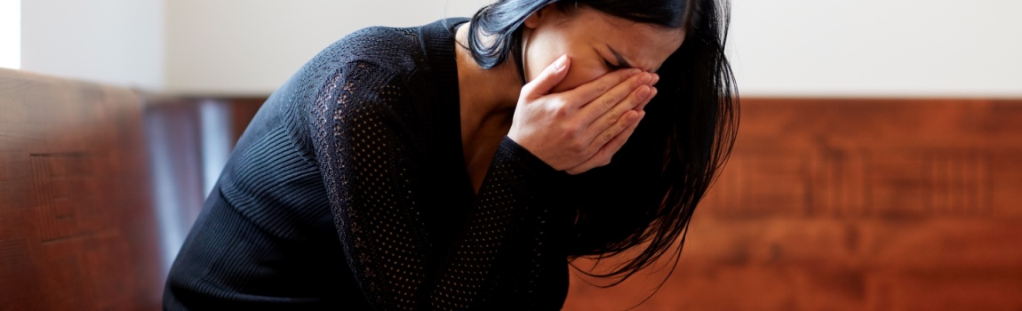 Crying woman in the chapel for her late husband memorial.