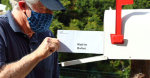 Man mailing in a ballot during the covid-19 pandemic.