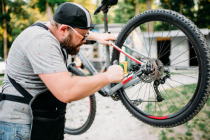Bicycle mechanic adjusts back disk brakes in preparation for summer riding.