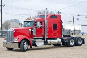 Woman driver in red bobtail trailer truck.