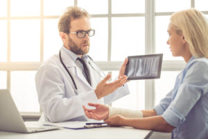 Doctor showing xray results of arm injury to patient.