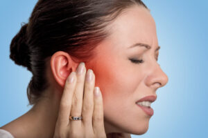 Woman having ear pain touching her ears.