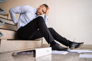 Businessman slip and fall in the stairways suffering backache from fall.