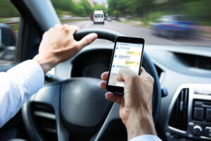 Distracted driver using his cellphone while driving.