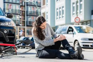 Woman cyclist hit by a car in the highway.