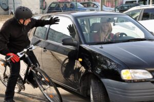 Bicycle rider almost got hit by a car.