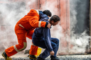 Fireman rescuing victim from blazing fire.