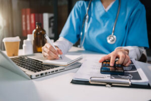 Doctor tallying for medical costs to patient.