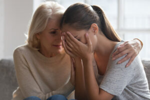 Sad woman seeking comfort with her mother.