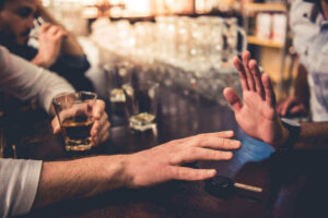Drunk driver at the dram shop reaching for his car keys.