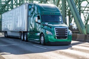 Green truck passing the bridge.