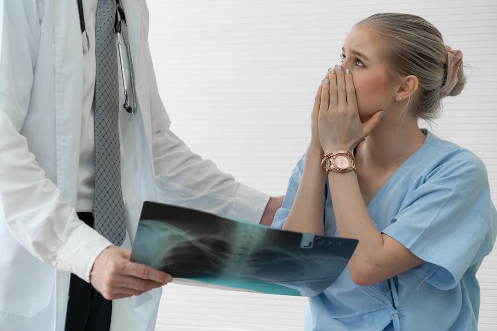 Young woman patient surprised and shocked when see film x-ray result with doctor had explain result and consult at hospital.