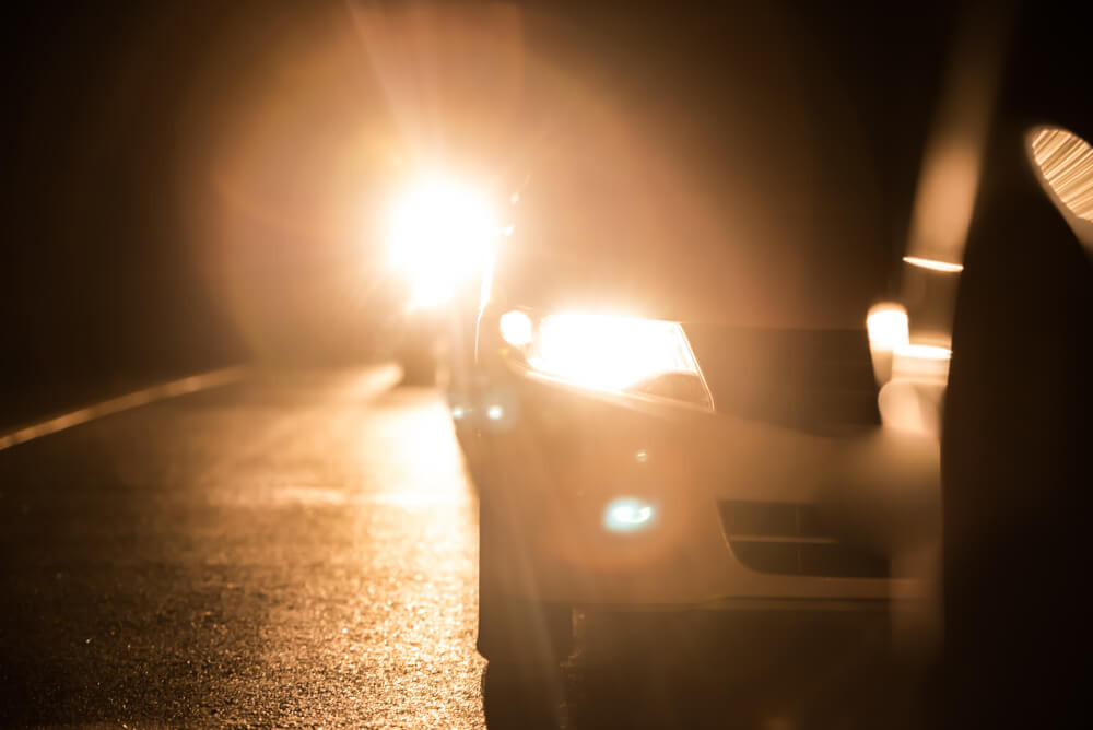 Car headlights high beam at night with bokhe on the street at night time,