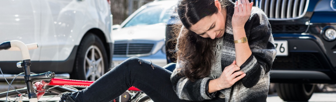 Woman riding bicycle got hit by a car.