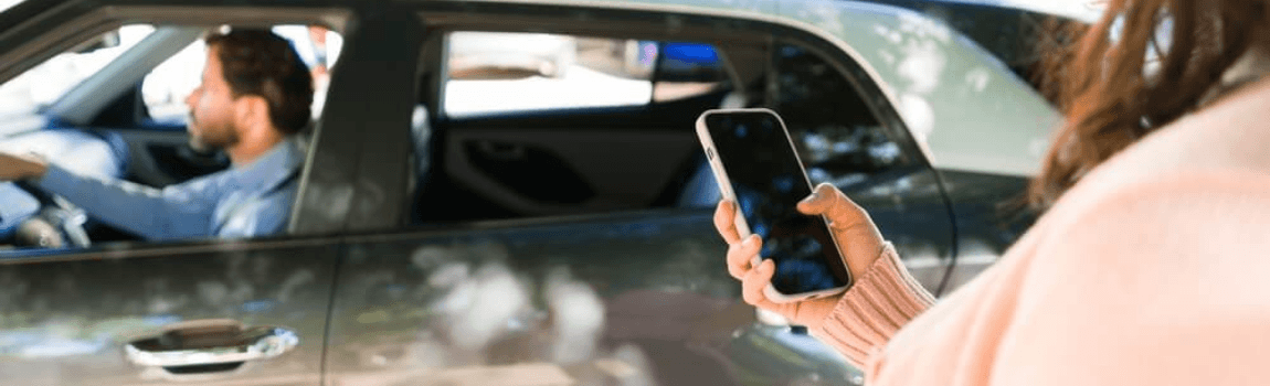 Lady passenger using ridesharing app to book a ride.