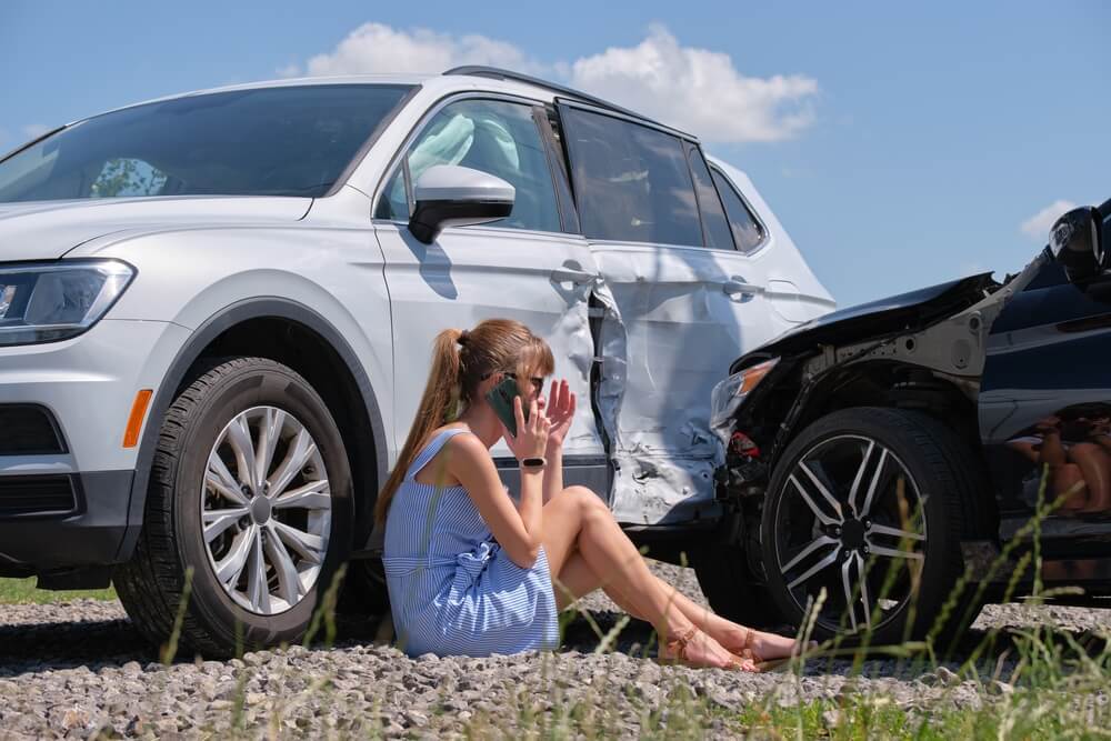 Lady driver calling the car rental company to report accident to file for insurance.