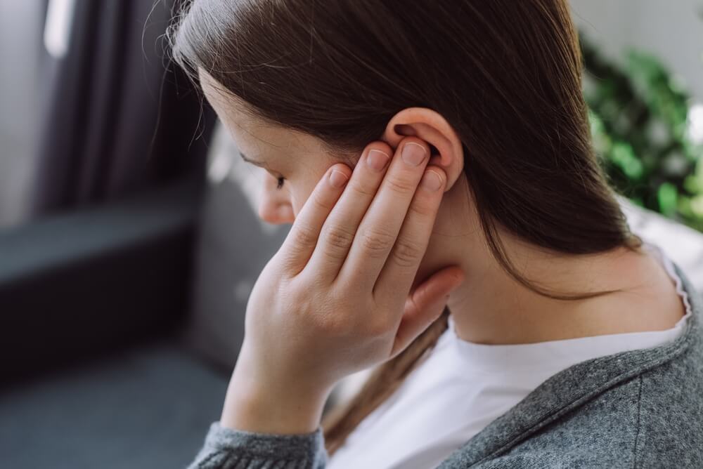 Lady feeling pain on hearing loss from car accident.